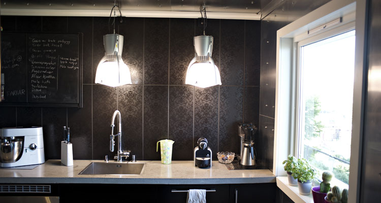 KJØKKENET: Aluminium, betong, svarte fliser og svart kjøkkeninnredning. FOTO: Eirik Brekke