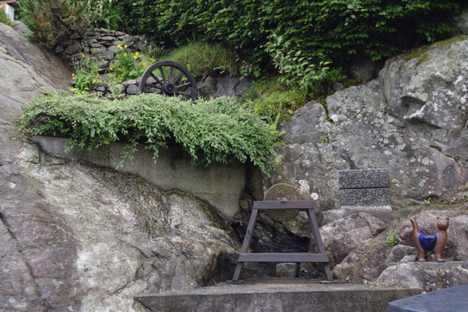 SITTEPLASS: Et gammelt kjerrehjul og en slipestein er pynt ovenfor sitteplassen. FOTO: Elisabeth Heggland Urø